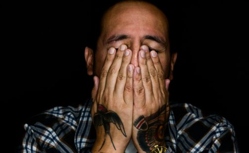 Mann hält Hände vor Gesicht